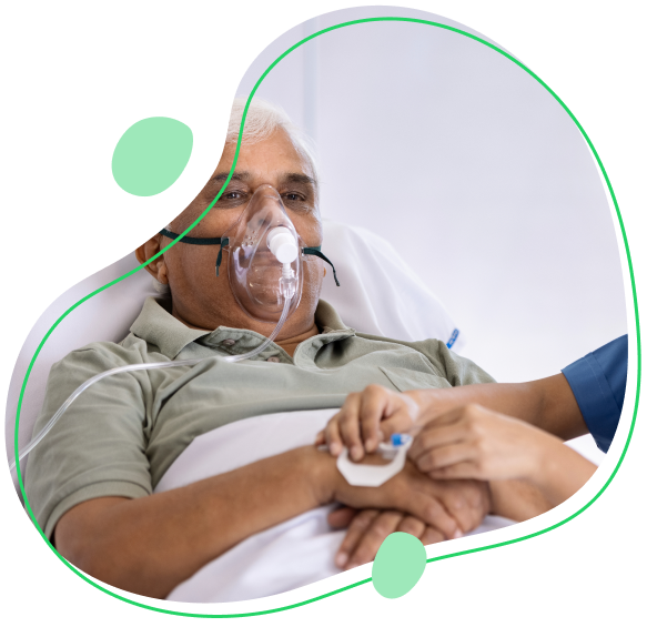 Healthcare professional setting IV drip for a senior patient in a hospital bed wearing an oxygen mask.
